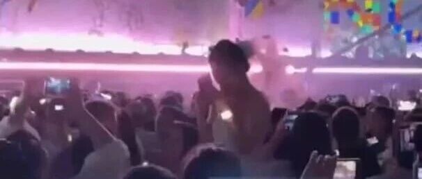 演唱会现场，男子向身穿婚纱女友求婚，遭后排大喊坐下；此前还向周围观众撒喜糖，保安随后介入制止